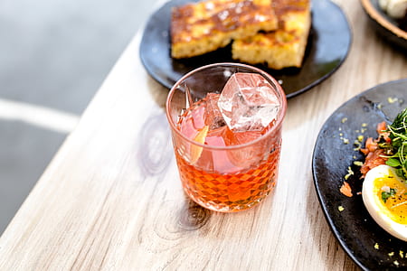 half-full drinking glass in between two plates on table top thumbnail