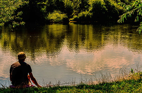 man sits near body of water thumbnail