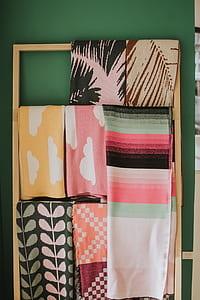 assorted-color textiles hanging on brown wooden rack thumbnail