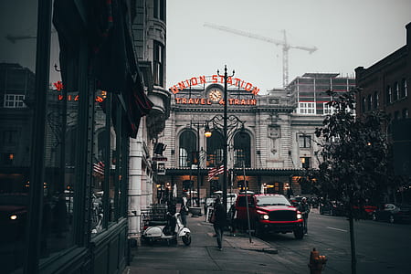 red SUV parked on sidewalk near buildings thumbnail