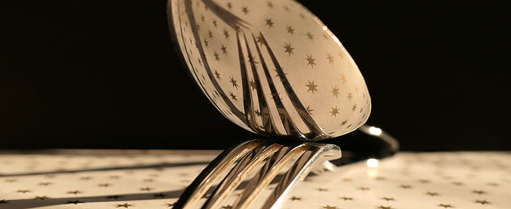 stainless steel spoon top of fork on table thumbnail