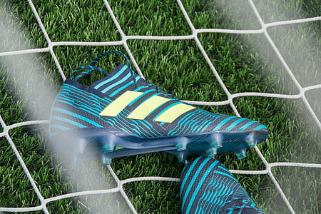 pair of green-and-black adidas cleats on white net thumbnail