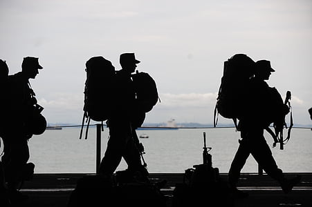 man in backpack walking on road thumbnail