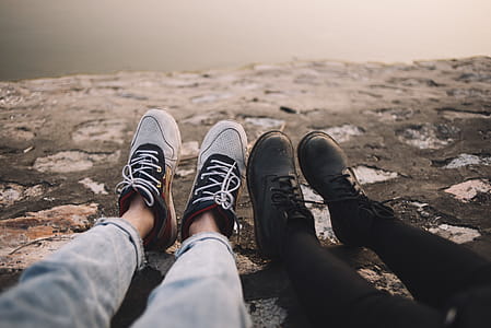 Two Person Wearing Pants and Shoes Sits on Ground at Daytime thumbnail