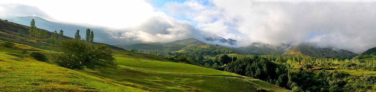 green grass field on hill under white clouds thumbnail