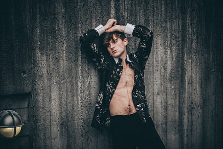 man leaning on gray wall thumbnail