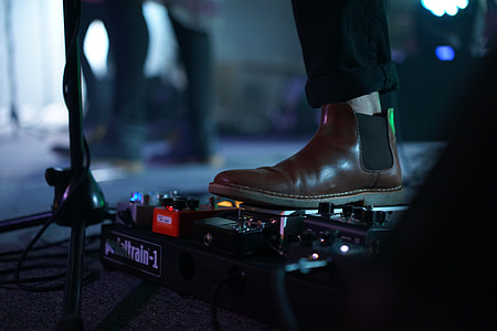 person in brown Chelsea boot stepping on effects pedal thumbnail