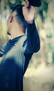 tilt shift lens photography of of man holding black pad thumbnail