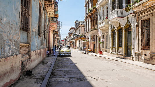 yellow car on road between buildings at daytime thumbnail