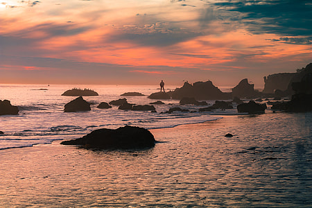 man standing on rock during sunset thumbnail