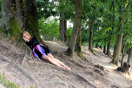 woman in black long-sleeved shirt sleeping near trees thumbnail