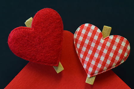 red and white fabric heart decors on red textile thumbnail