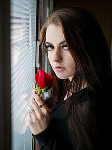 woman holding rose facing glassed mirror thumbnail