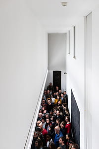 people standing inside white painted room thumbnail