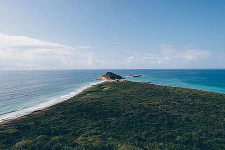 aerial photography of island under calm blue sky thumbnail