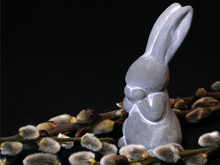 gray rabbit figurine beside green plants