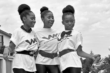 grayscale photo of three girl with matching outfits thumbnail