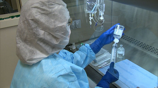 medical personnel injecting a syringe in a bottle thumbnail
