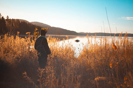 landscape photography of man facing body of water thumbnail