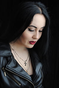 woman in black leather jacket looking down while taking her picture thumbnail