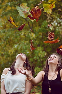 two women throwing leaves thumbnail