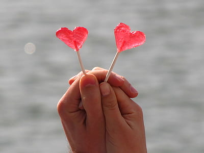 person holds heart-shaped candy pops thumbnail