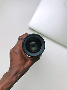 person holding camera lens thumbnail