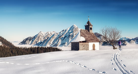 brown concrete house near bare tree during snow thumbnail