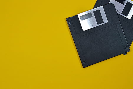 two black floppy discs on yellow surface thumbnail