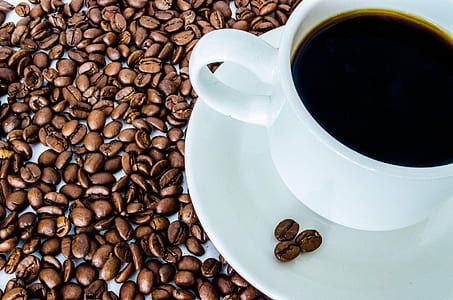 black coffee beans near white teacup on saucer thumbnail