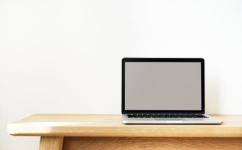 MacBook Pro on top of brown wooden table thumbnail
