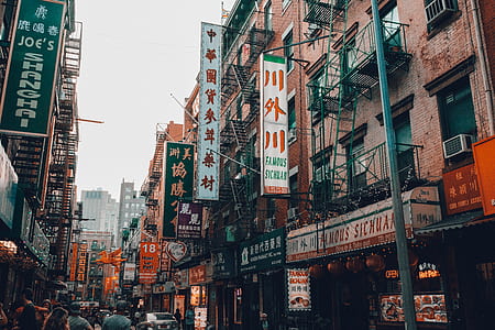 people walking in market surrounded with buildings during daytime thumbnail