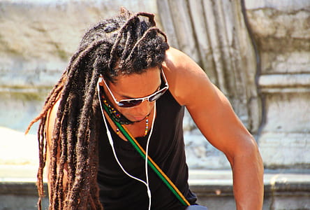 man in black tank top using white earphones thumbnail