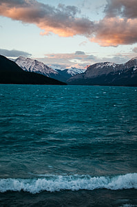 blue seat surrounded by mountains under cloudy sky thumbnail