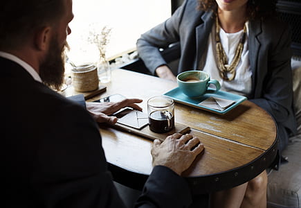 man and woman talking by the table with cup of coffees thumbnail