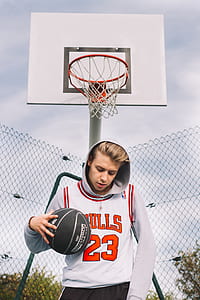 man dribbling ball in front of basketball system during daytime thumbnail