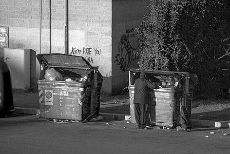 grayscale photo of person looking at trash bin thumbnail