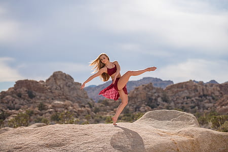woman standing on brown rock formation in dance form thumbnail