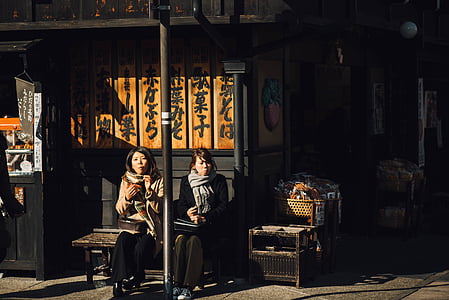 two women sitting on bench thumbnail