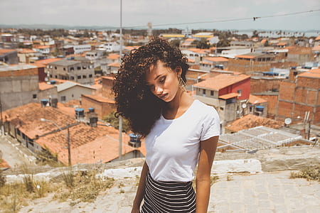 photo of woman in white scoop-neck top and black and white stripe skirt thumbnail