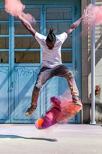 timelapse photo of man jump with skateboard and assorted-color powders at daytime thumbnail