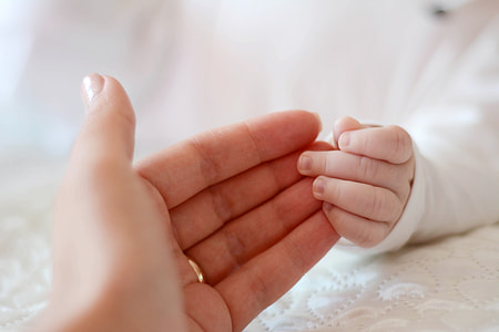 person's hand touching toddler's hand thumbnail