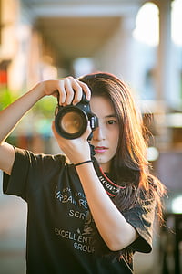 woman wearing shirt while holding canon dslr camera thumbnail