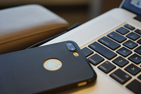 gold iPhone 7 Plus and black case on silver MacBookj thumbnail