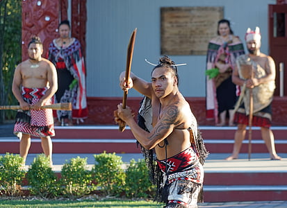 standing man in traditional suit holding wooden sword thumbnail