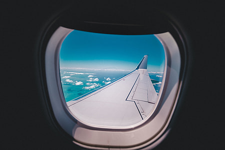 photograph of flying airplane wing viewed inside windshield thumbnail