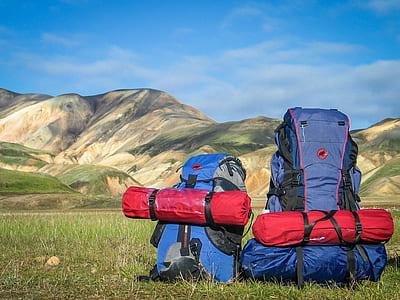 blue and red camping bag on green grass field thumbnail