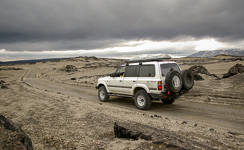 white SUV on road under cloudy sky thumbnail