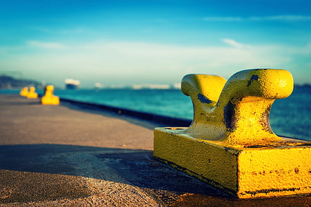 yellow steel component near large body of water thumbnail