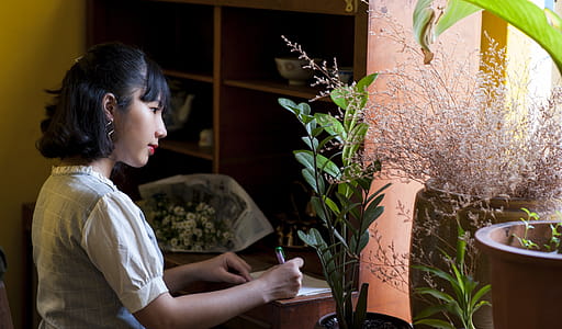 Photography of Woman Wearing White and Gray Top Writing thumbnail